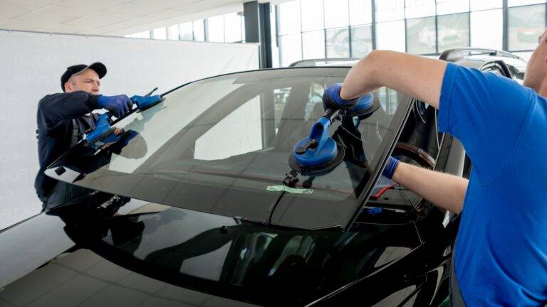 Two men installing windscreen