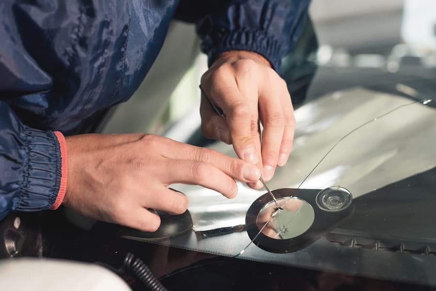 Man using tools on windscreen crack