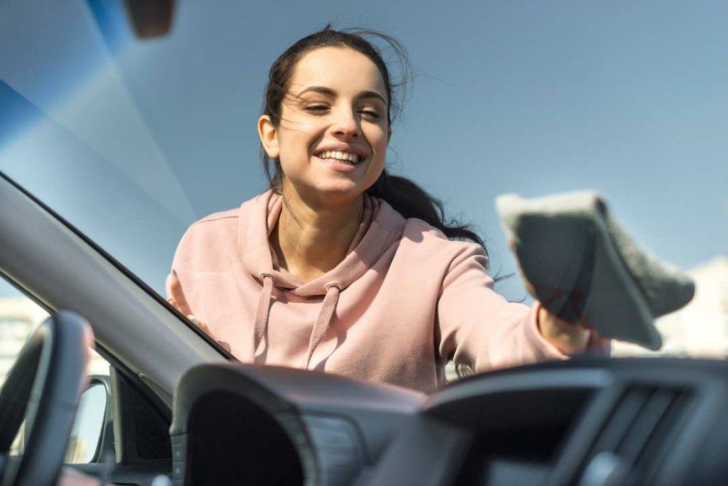 Woman Wiping Down The Front Windscreen On Her Car