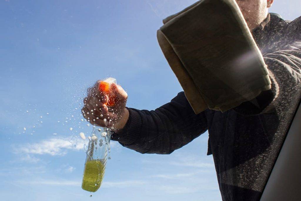 Spraying down glass with glass cleaner